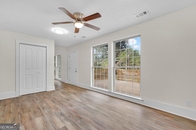 empty room with light wood-type flooring and ceiling fan