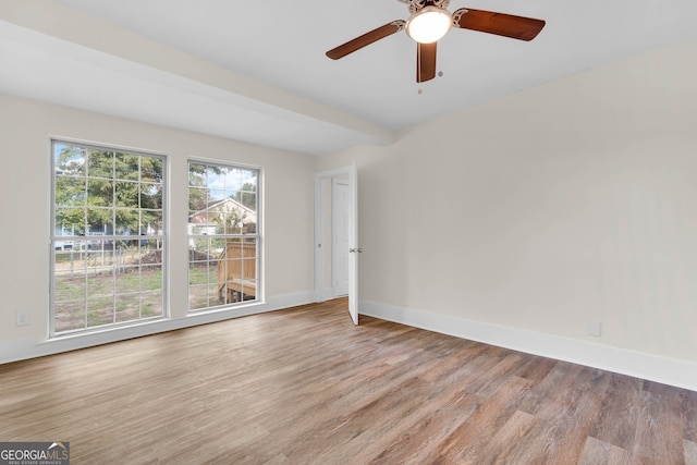 unfurnished room featuring light wood-type flooring, ceiling fan, and beam ceiling