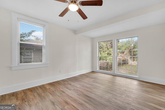 unfurnished room with a wealth of natural light, ceiling fan, and light hardwood / wood-style flooring