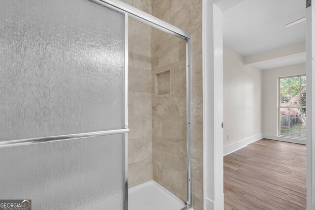 bathroom with hardwood / wood-style floors and walk in shower