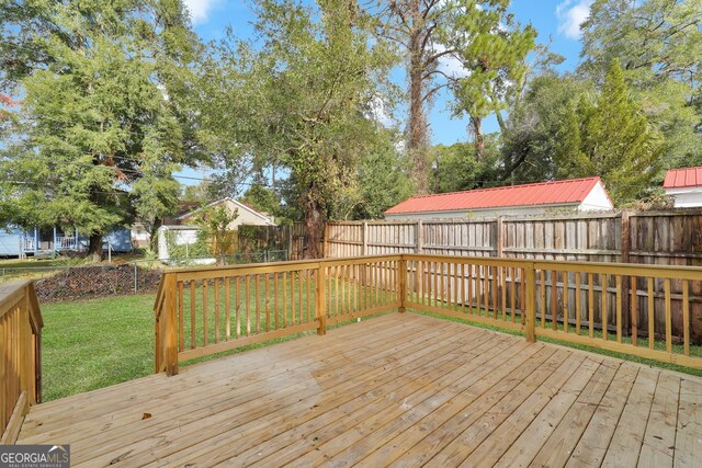 wooden deck featuring a lawn