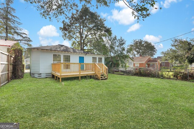 back of property featuring a yard and a wooden deck