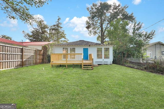 back of property featuring a lawn and a deck