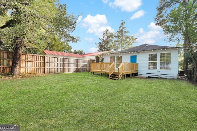 back of house featuring a lawn and a wooden deck