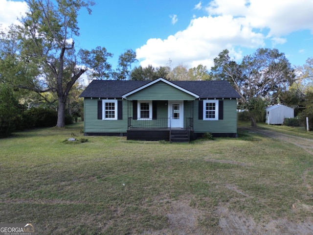 view of front of property featuring a storage shed and a front lawn