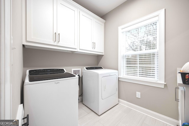 laundry room with washer and clothes dryer and cabinets