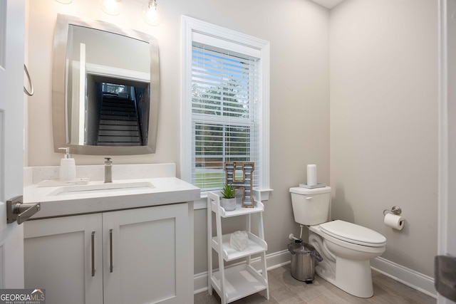 bathroom featuring vanity, a healthy amount of sunlight, and toilet