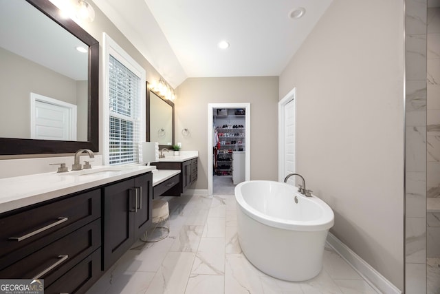 bathroom with a washtub and vanity