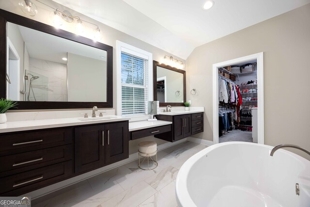 bathroom with vanity, independent shower and bath, and lofted ceiling