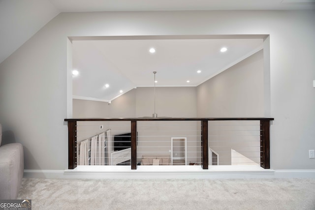 hall with ornamental molding, vaulted ceiling, and carpet floors