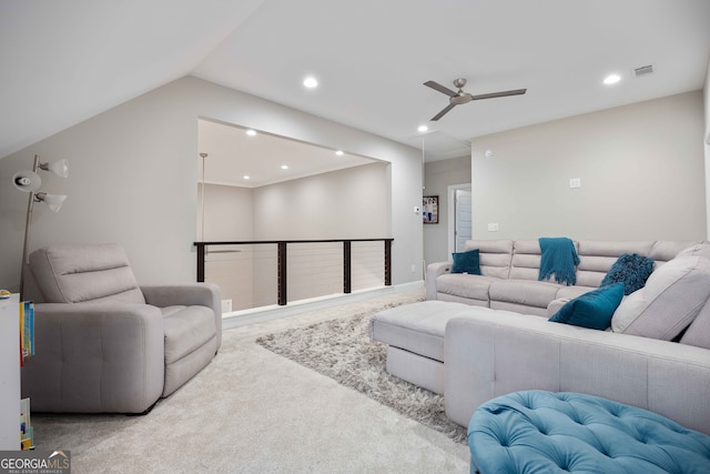 carpeted living room with ceiling fan and vaulted ceiling