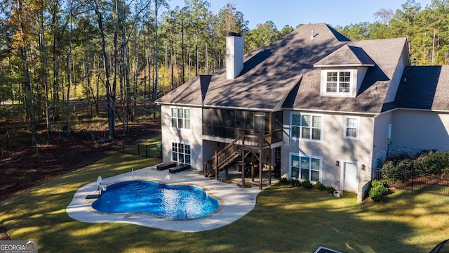 rear view of property with a lawn and a fenced in pool