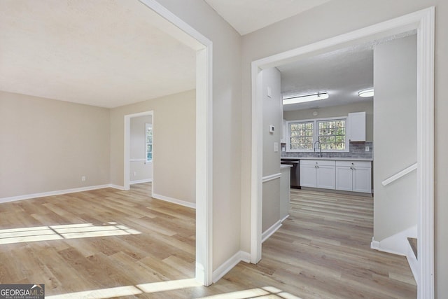 hall with light hardwood / wood-style flooring and sink