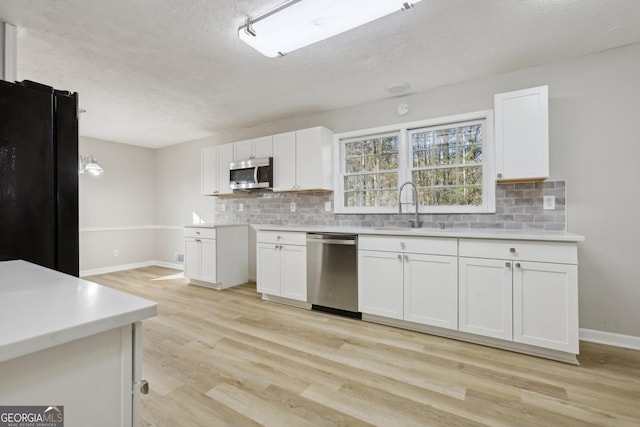 kitchen featuring white cabinetry, sink, appliances with stainless steel finishes, and light hardwood / wood-style flooring