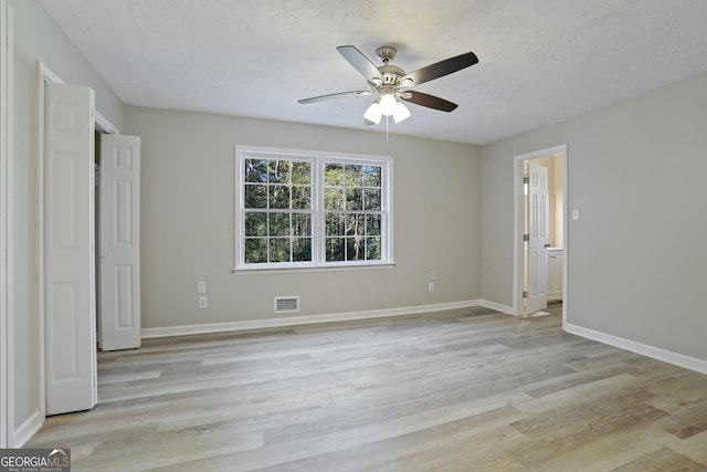 unfurnished bedroom with ceiling fan, a textured ceiling, and light hardwood / wood-style flooring