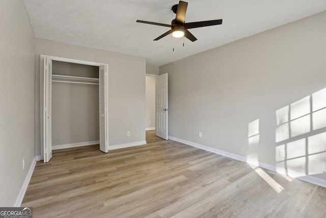 unfurnished bedroom featuring ceiling fan, a closet, and light hardwood / wood-style flooring