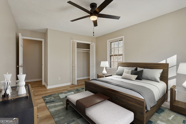 bedroom with a closet, light hardwood / wood-style flooring, and ceiling fan