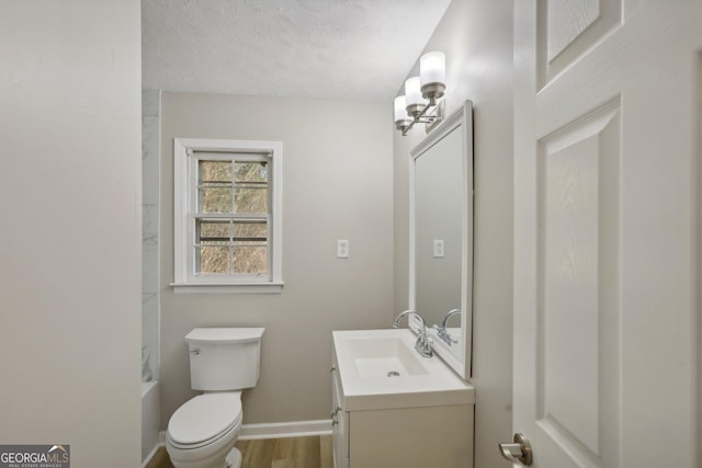 bathroom with hardwood / wood-style floors, vanity, toilet, a textured ceiling, and a chandelier