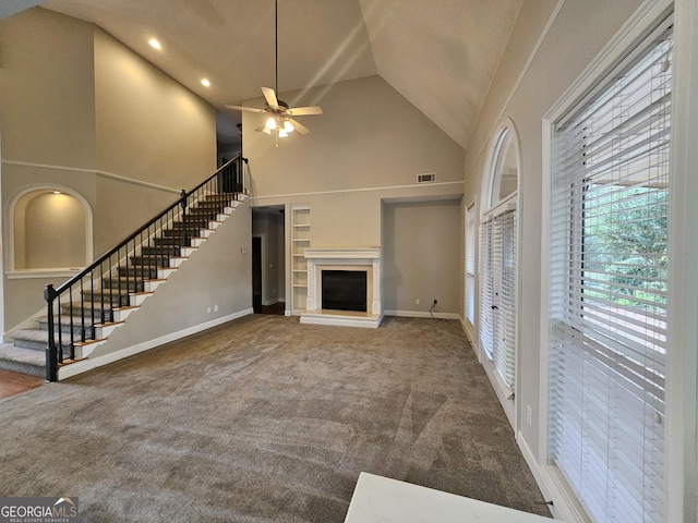 unfurnished living room featuring carpet flooring, ceiling fan, and high vaulted ceiling