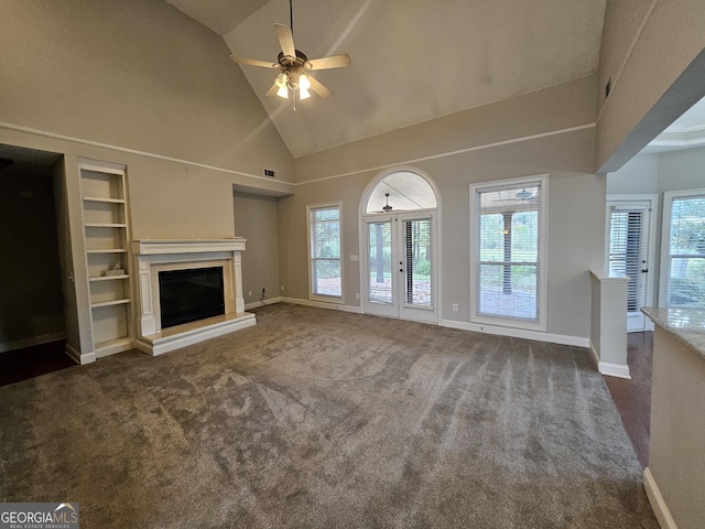 unfurnished living room with french doors, dark carpet, ceiling fan, high vaulted ceiling, and built in features