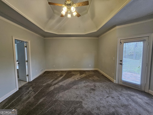 carpeted spare room with ceiling fan, ornamental molding, and a tray ceiling