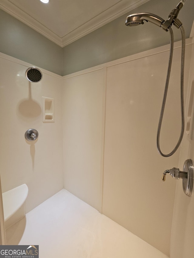 bathroom featuring a shower, toilet, and crown molding