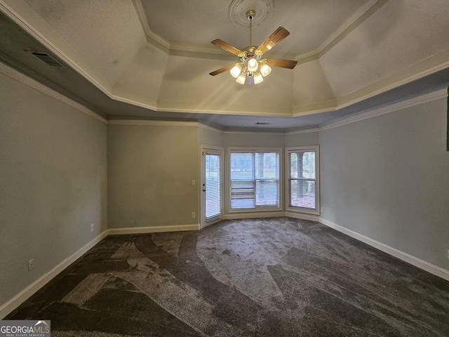 spare room featuring a raised ceiling, crown molding, ceiling fan, and dark carpet