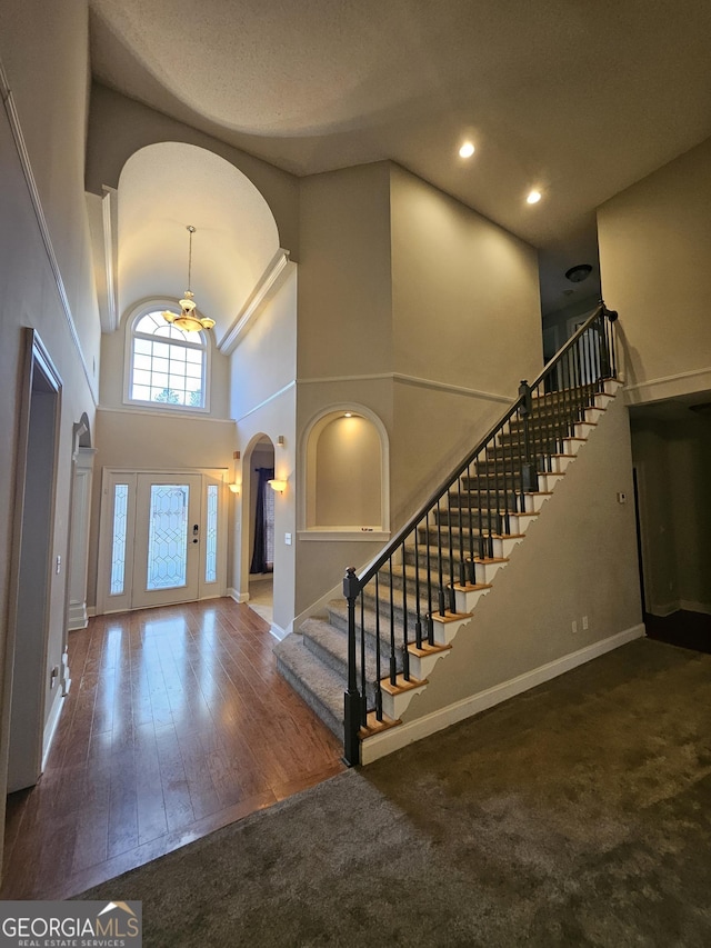 foyer featuring dark hardwood / wood-style floors and a towering ceiling