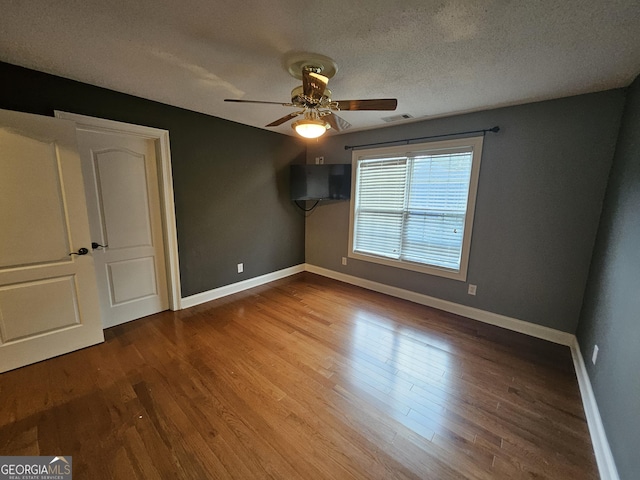 unfurnished bedroom with hardwood / wood-style floors, a textured ceiling, and ceiling fan