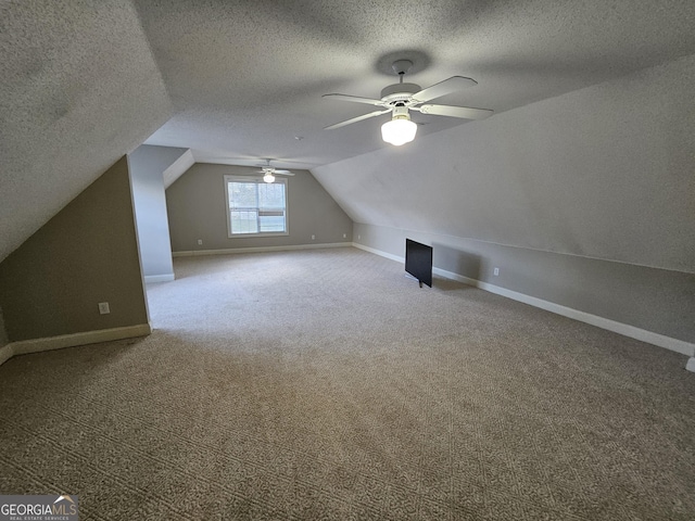 bonus room with a textured ceiling, ceiling fan, carpet, and vaulted ceiling