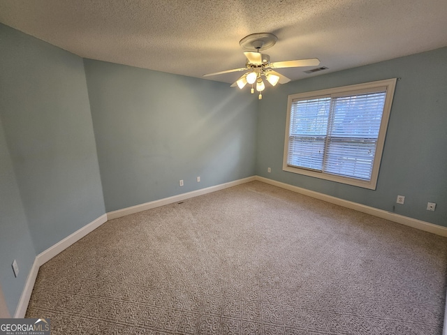 carpeted spare room with ceiling fan and a textured ceiling