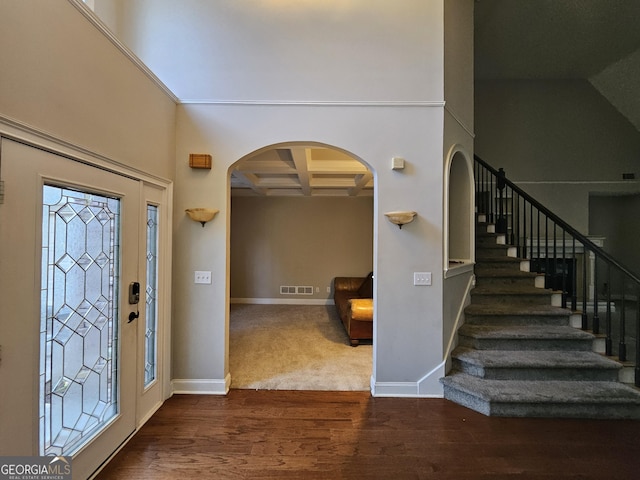 foyer featuring dark hardwood / wood-style flooring, beamed ceiling, a high ceiling, and coffered ceiling