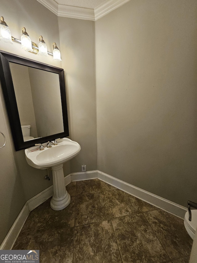 bathroom with ornamental molding and toilet