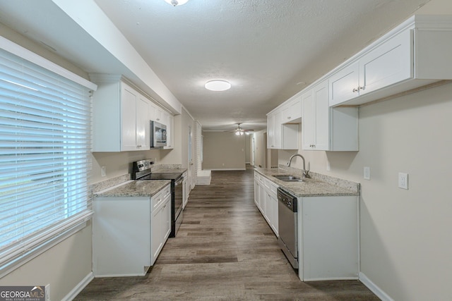 kitchen featuring stainless steel appliances, white cabinets, a textured ceiling, sink, and light hardwood / wood-style flooring