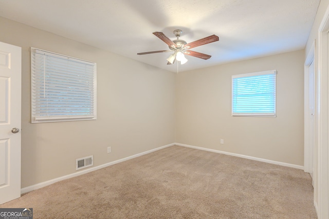 empty room featuring ceiling fan and light carpet