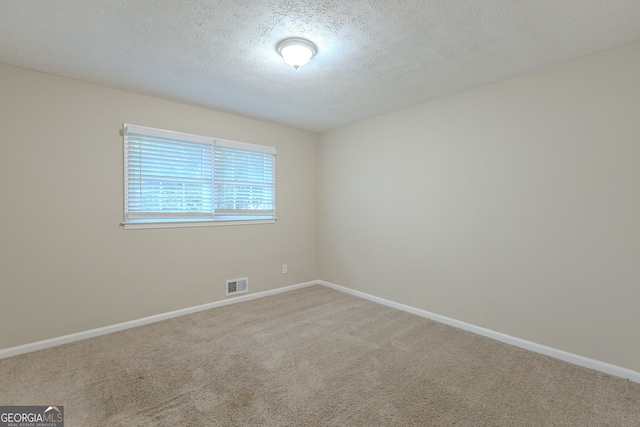 spare room featuring a textured ceiling and carpet flooring