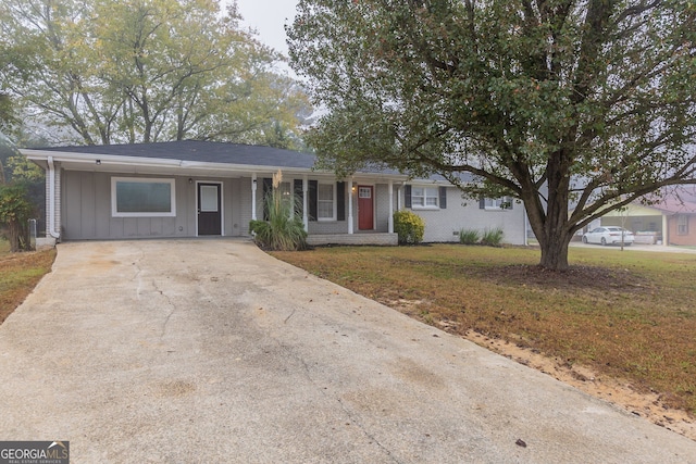 ranch-style home featuring a front lawn and a carport