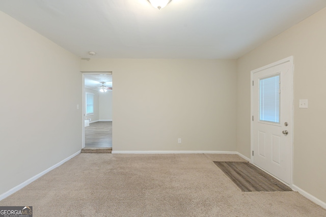 carpeted empty room featuring a wealth of natural light and ceiling fan