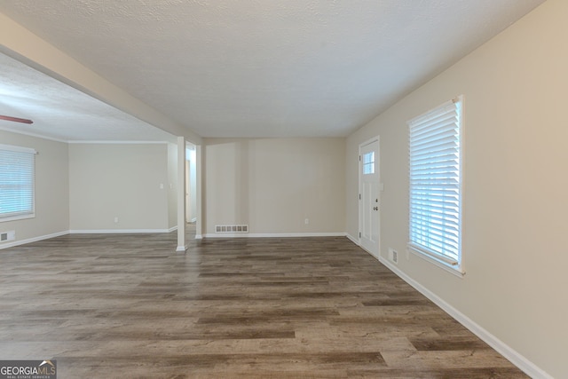 spare room featuring wood-type flooring, ceiling fan, and a textured ceiling