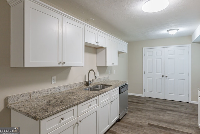 kitchen featuring white cabinetry, sink, light stone counters, stainless steel dishwasher, and dark wood-type flooring