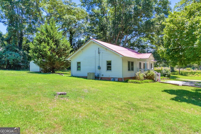 view of home's exterior with a storage shed, a lawn, and central air condition unit