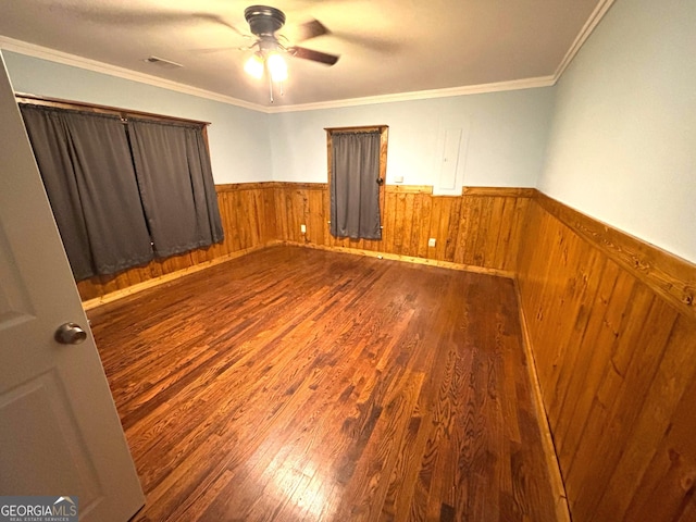 empty room with crown molding, ceiling fan, and dark hardwood / wood-style floors