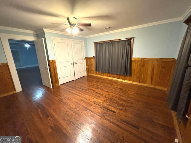 unfurnished bedroom with dark hardwood / wood-style flooring, crown molding, and ceiling fan