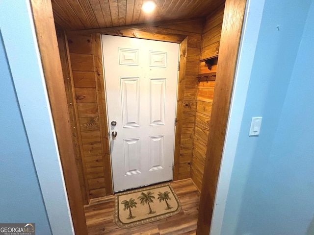 entryway with lofted ceiling, wooden walls, wooden ceiling, and wood-type flooring