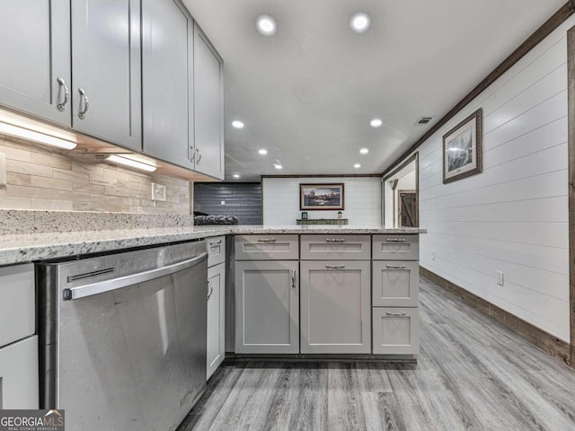 kitchen with gray cabinetry, stainless steel dishwasher, and hardwood / wood-style flooring