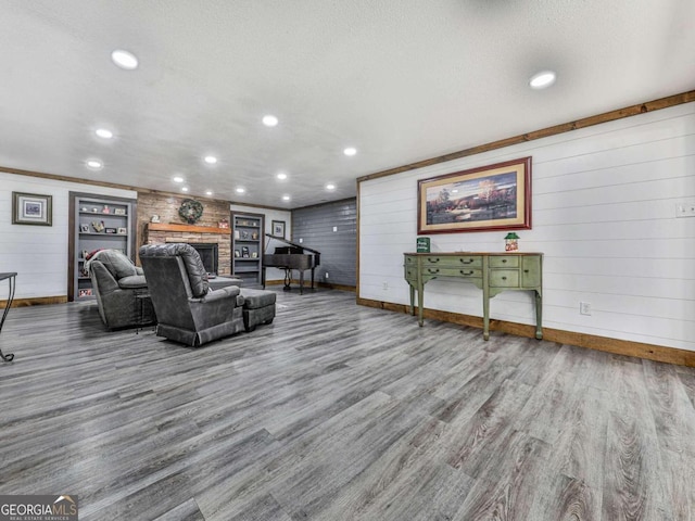 living room featuring hardwood / wood-style floors, a fireplace, wood walls, and a textured ceiling