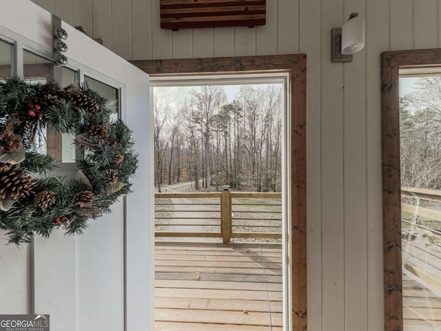 doorway to outside with wood walls