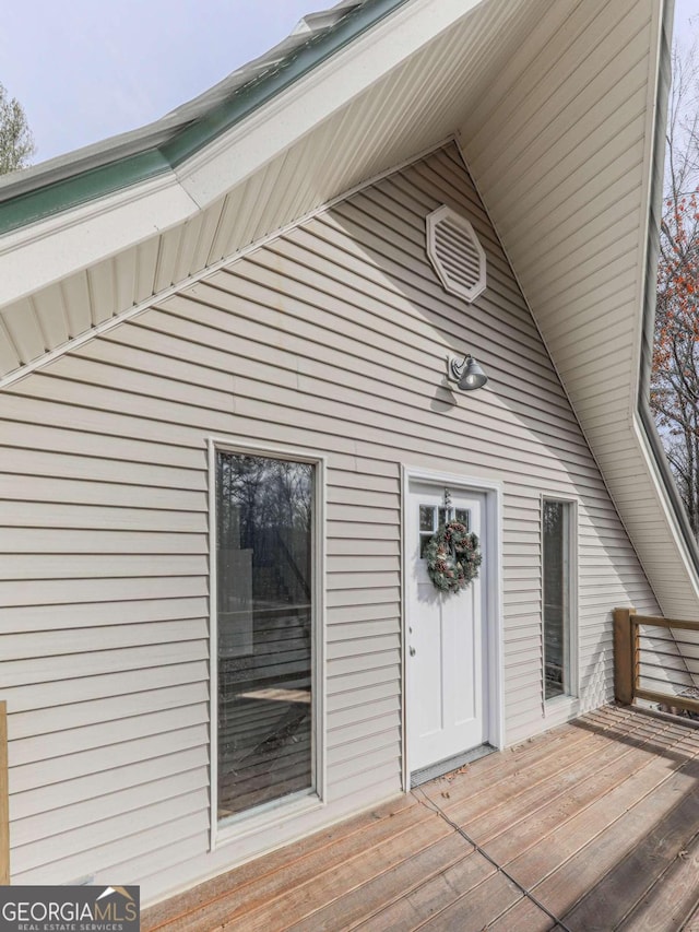 view of exterior entry featuring a wooden deck