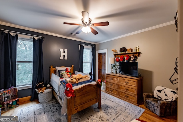 bedroom featuring hardwood / wood-style floors, ceiling fan, and crown molding