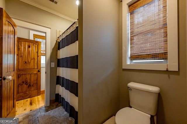 bathroom with hardwood / wood-style flooring, toilet, and a shower with curtain